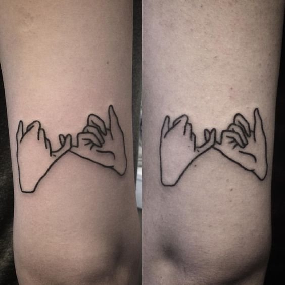 two hands holding each other tattoo
