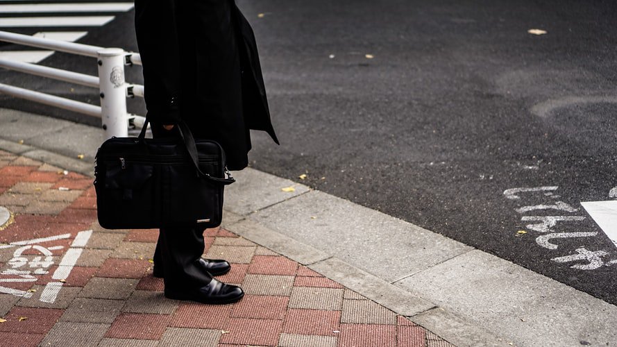 Who are the security men in black with briefcases around the PM on