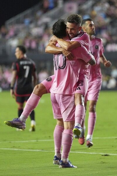 Inter Miami players hugging and celebrating in pink kits