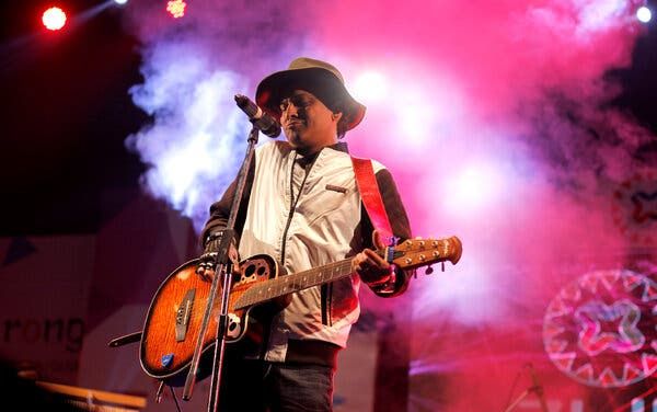 Zubeen Garg performing on stage, magenta fog