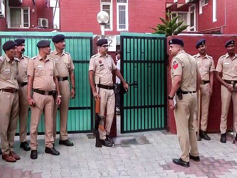 Haryana police officers at the gate—the tense, guarded mood around official premises after both suicides.
