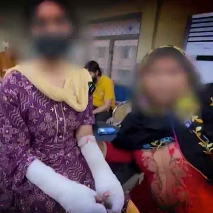 Two women, one with hands bandaged, at hospital